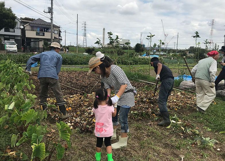 土壌還元作業に子どもと一緒に参加する利用者。障がい者施設に生ごみの発酵を促す竹パウダーの袋詰め作業を依頼するなど、多世代・多様な人々が関わる（画像提供／新保奈穂美さん）